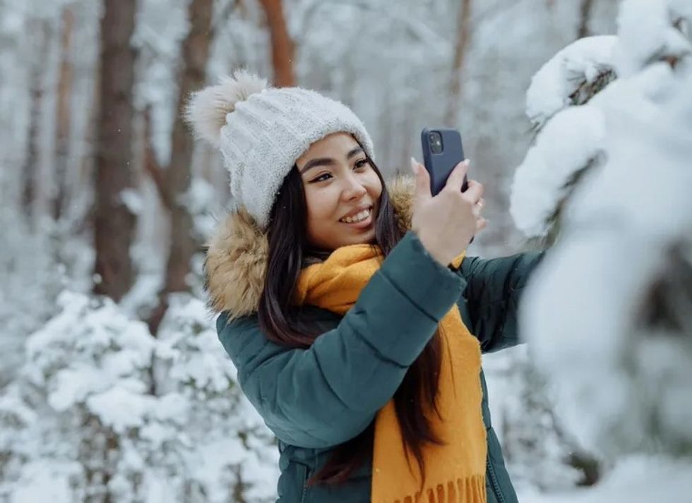 woman taking a picture of the winter snow