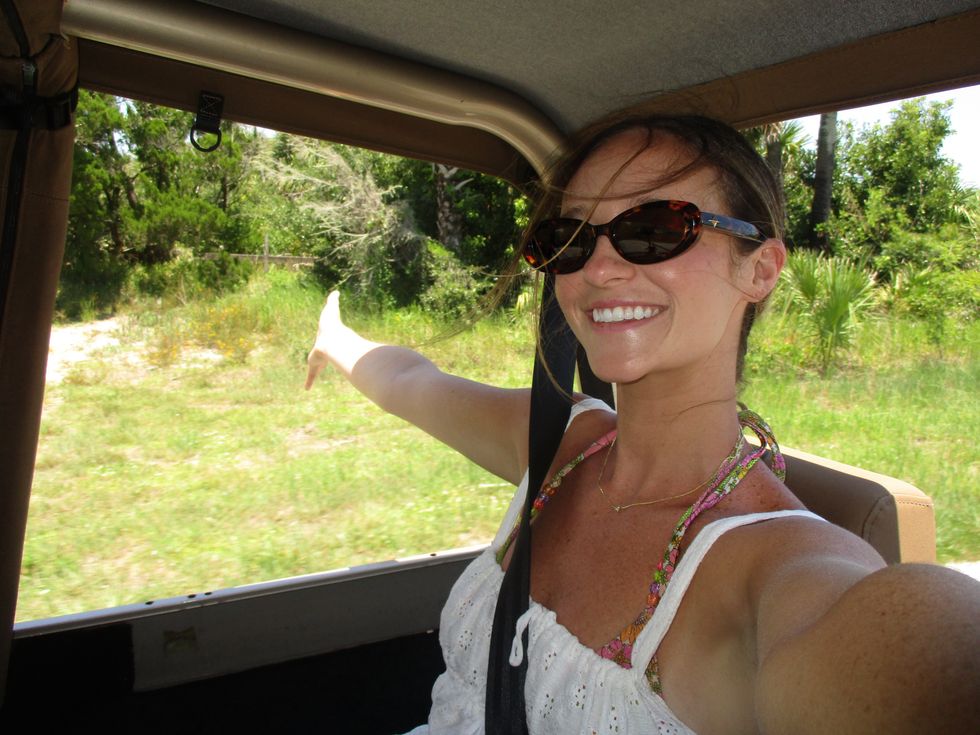 woman taking a selfie out of the car window