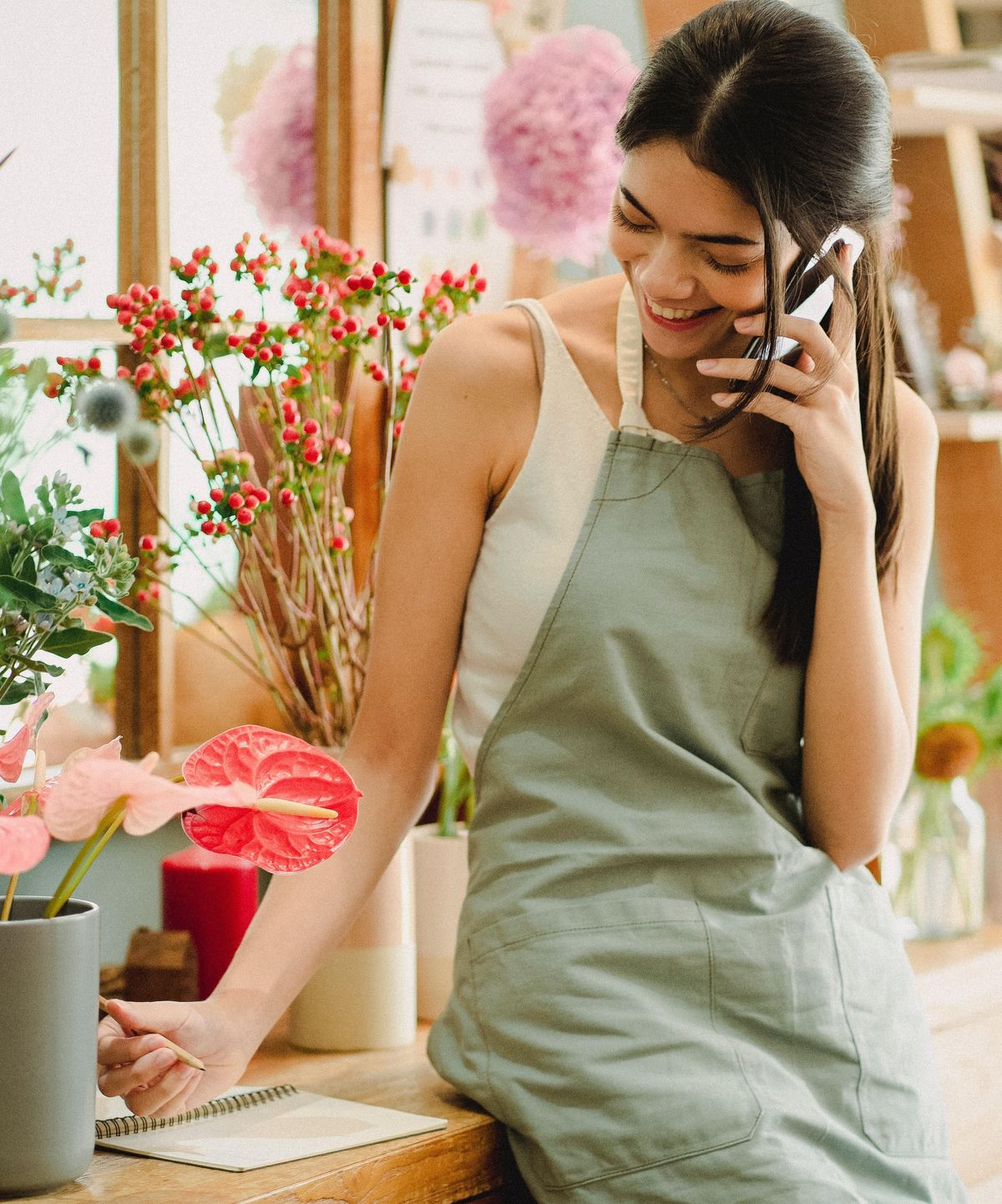Woman talking on the phone in a flower shop.