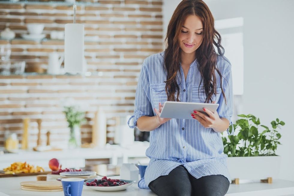 Woman using digital tablet in kitchen