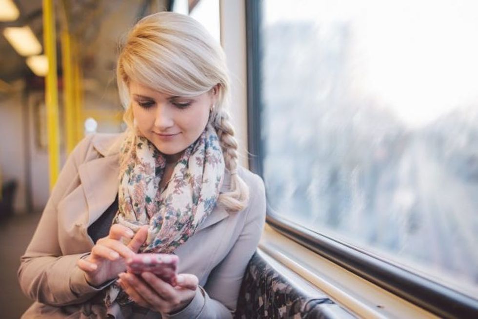 Woman using smart phone in subway