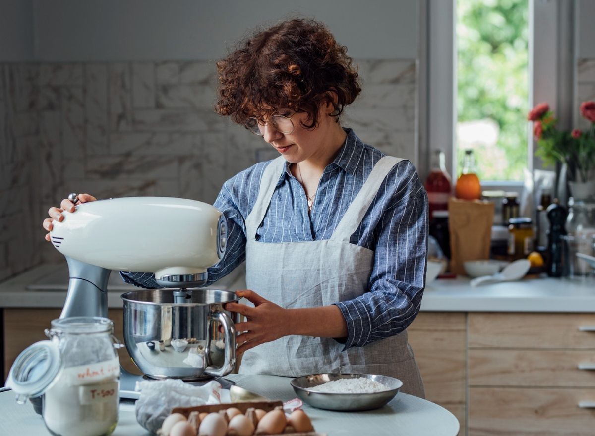 Woman using stand mixer in kitchen