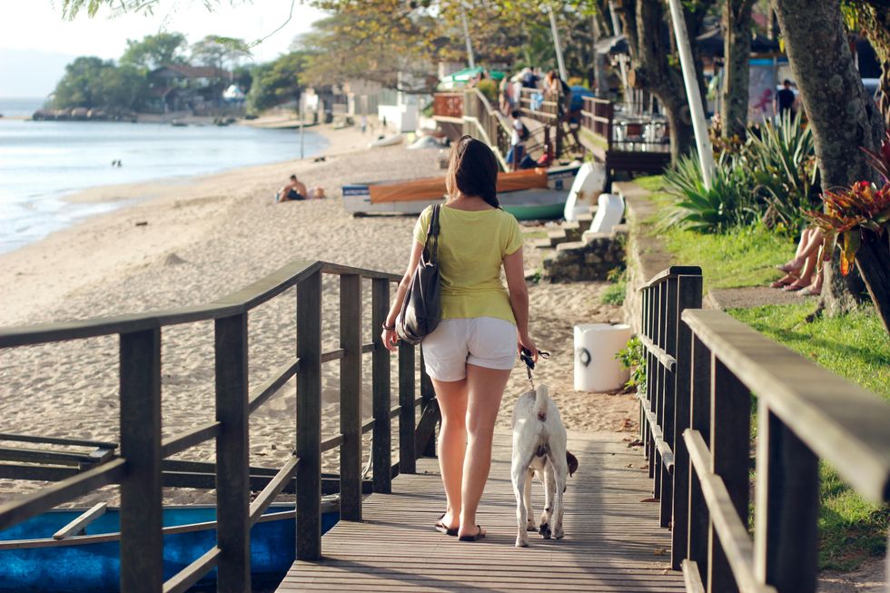 woman walking her dog to the beach