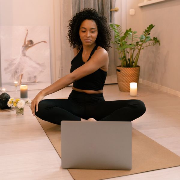 woman watching yoga routine on laptop