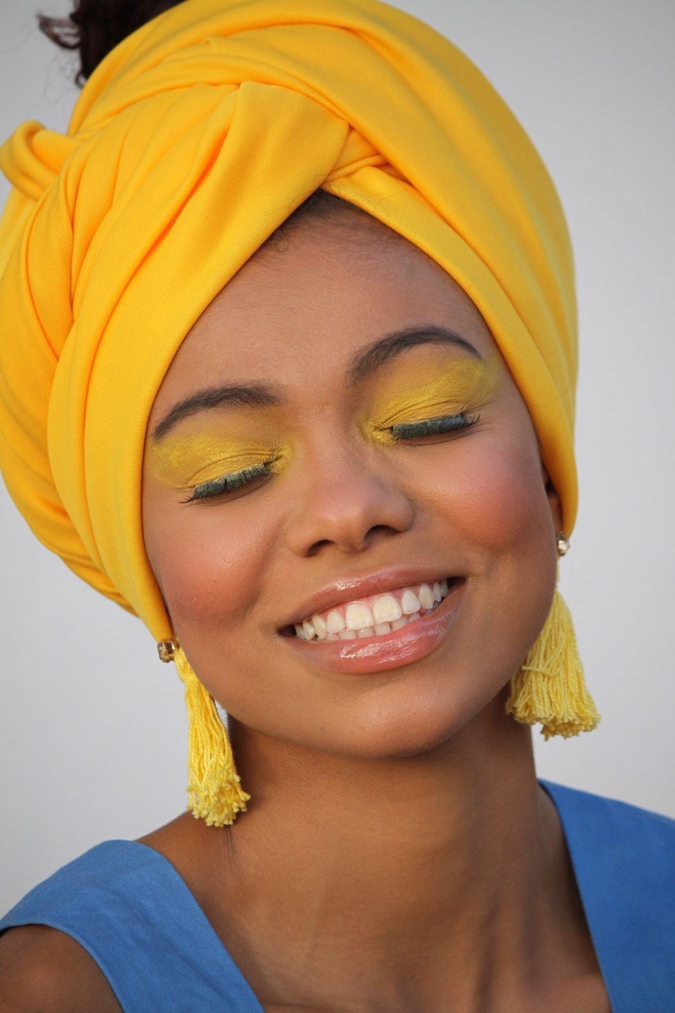 woman wearing a yellow headscarf smiling