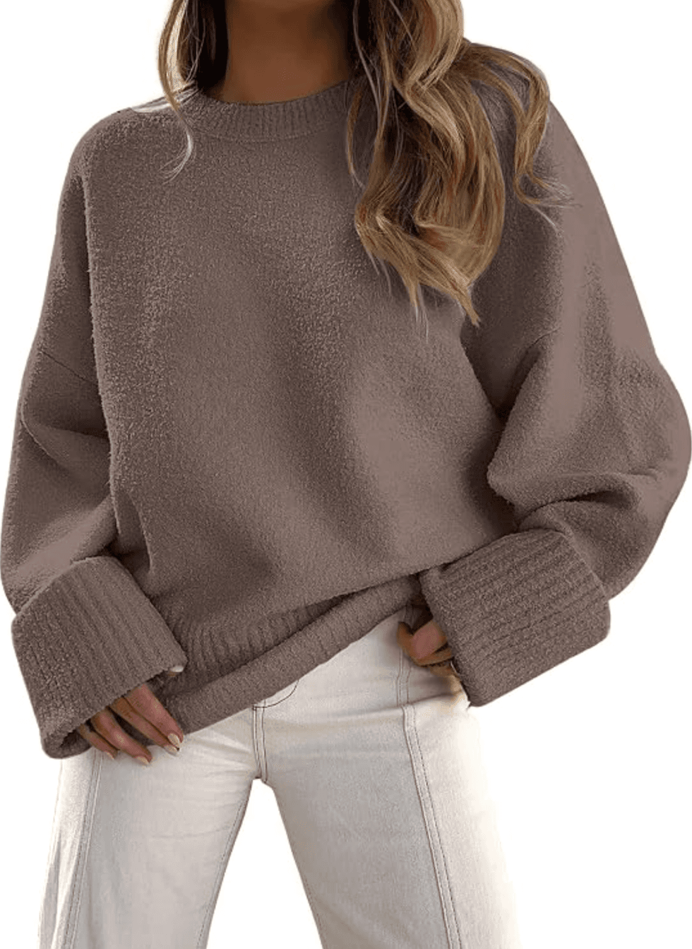 Woman wearing an oversized brown sweater and white jeans.