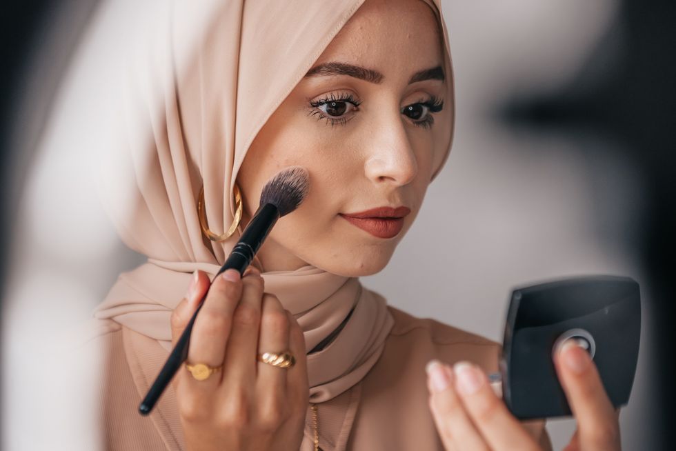 woman wearing Hijab putting on makeup