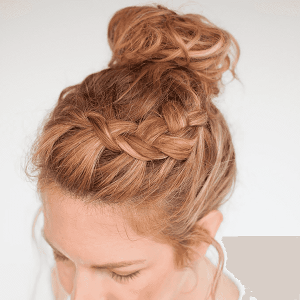 Woman with braided crown and messy bun hairstyle.