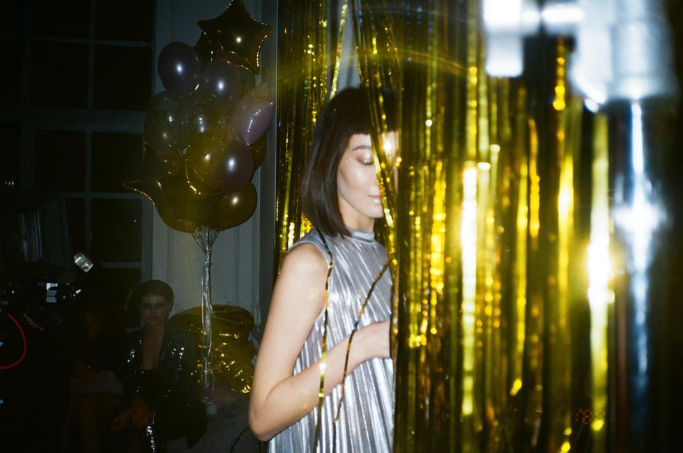 woman with glittering gold tinsel curtain