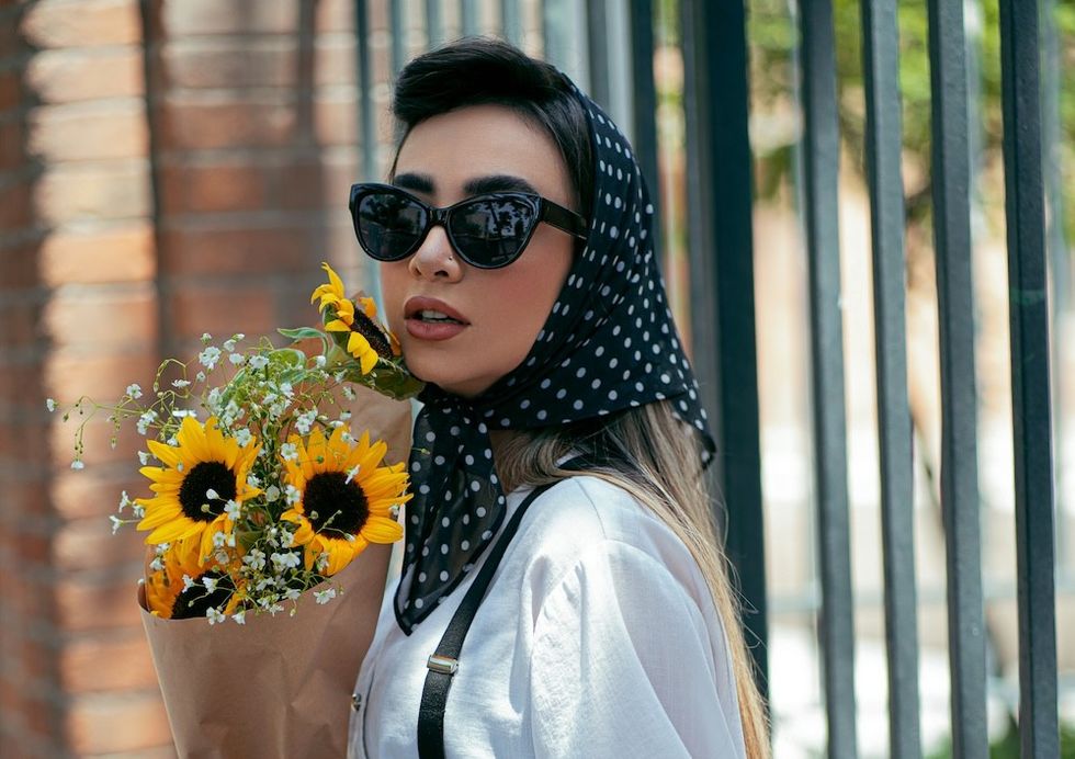 woman with sunflowers and a headscarf