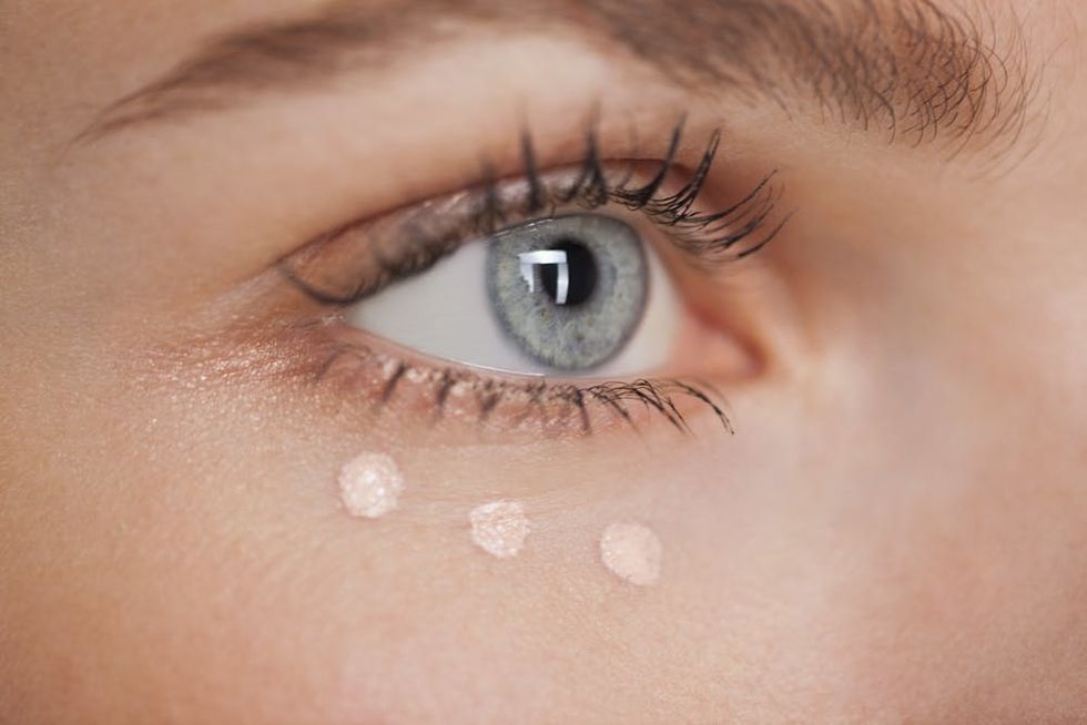 Woman with three dots of concealer under her eye.