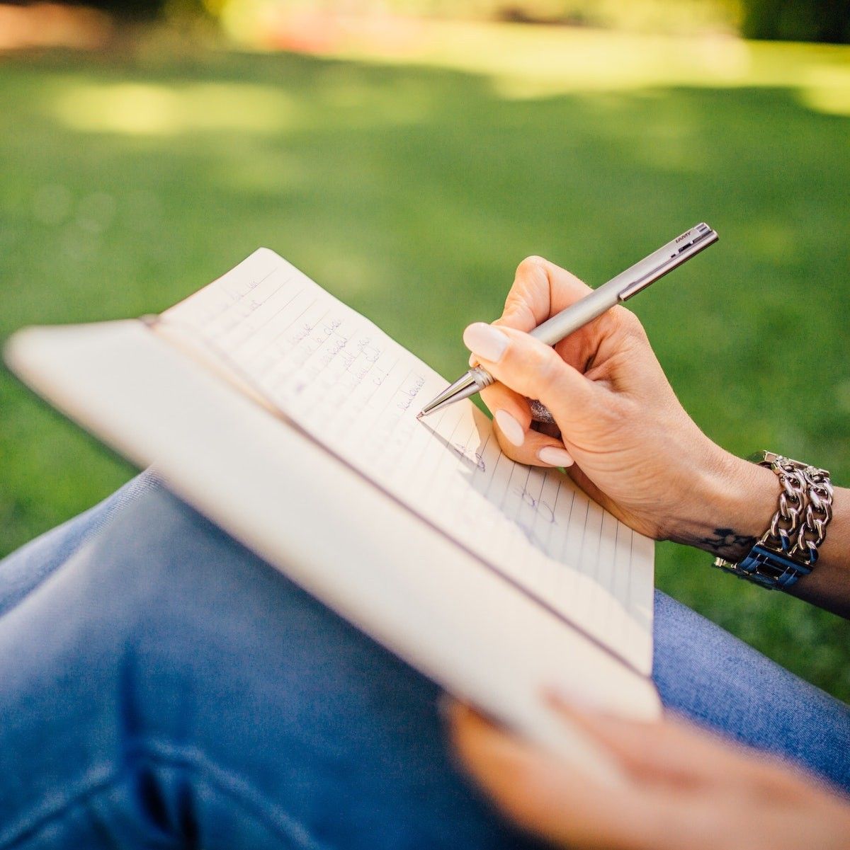woman writing outside spring journal prompts for 2023