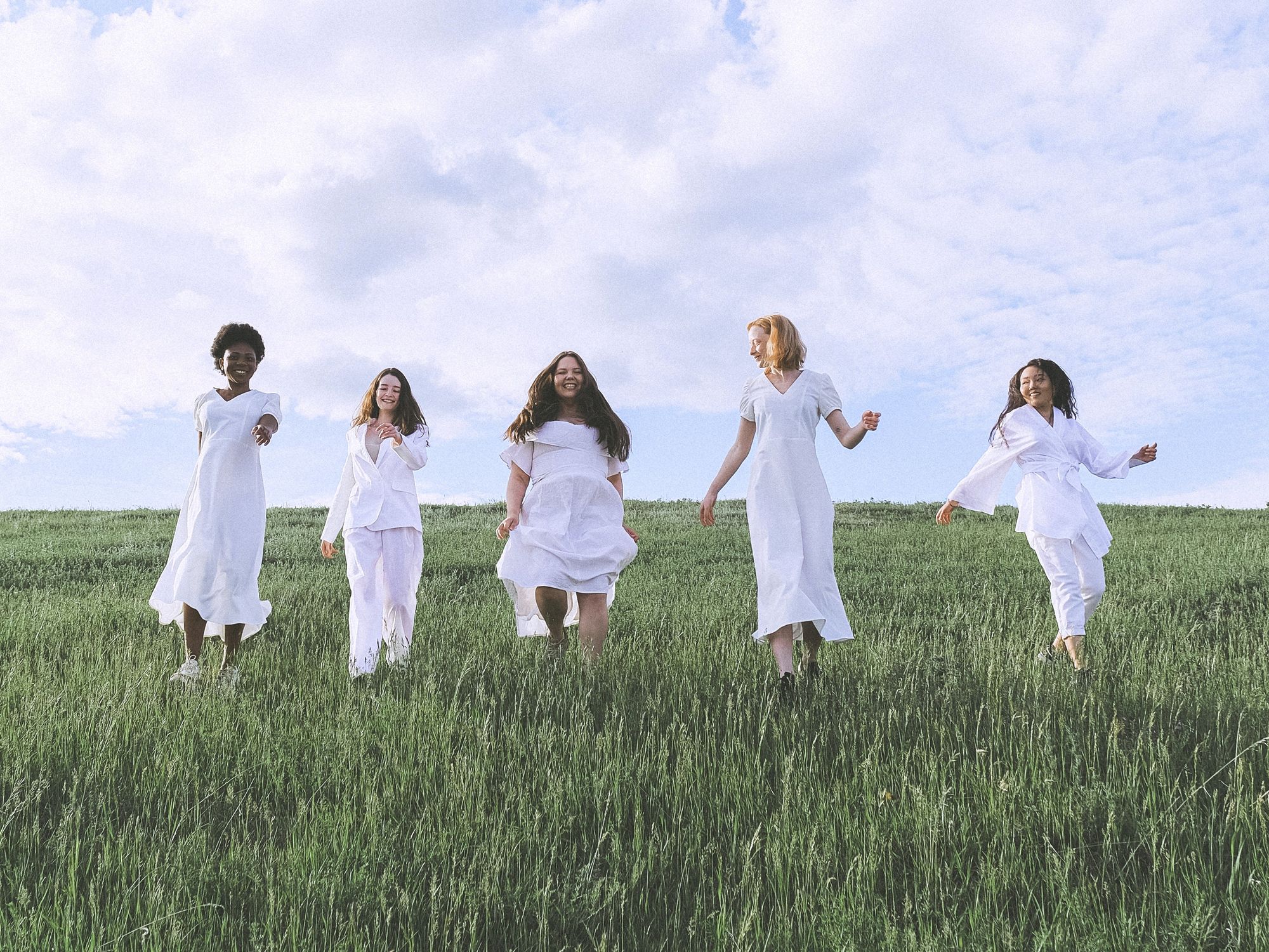 women together in a grass field