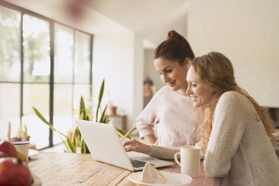 Women using laptop at dining table