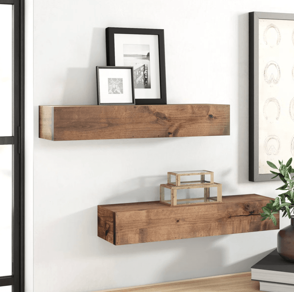 Wooden floating shelves with framed photos and decorative boxes on a white wall.
