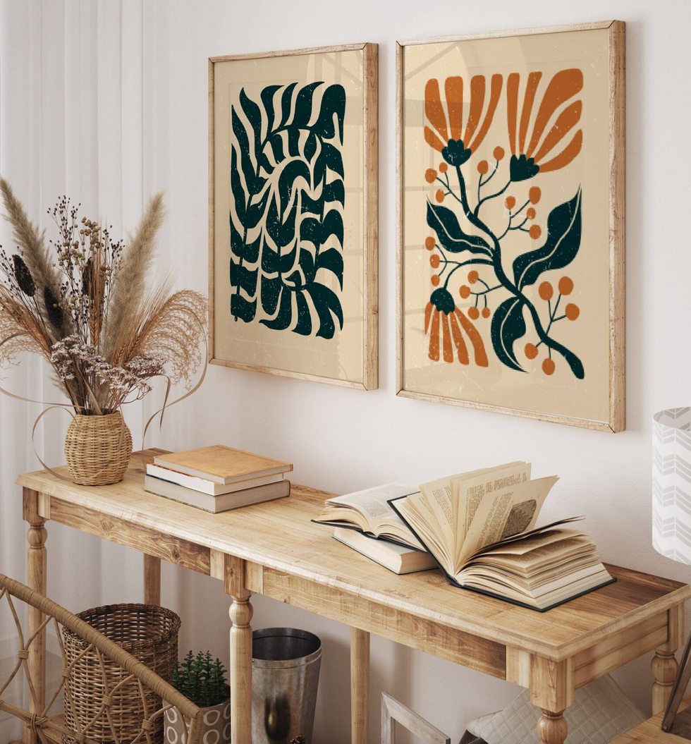 Wooden table with books, abstract plant art, pampas grass in a basket.
