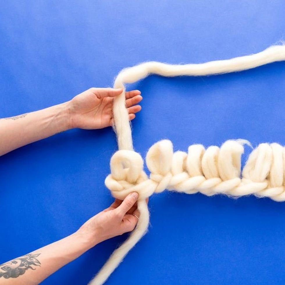 working with yarn on a blue table