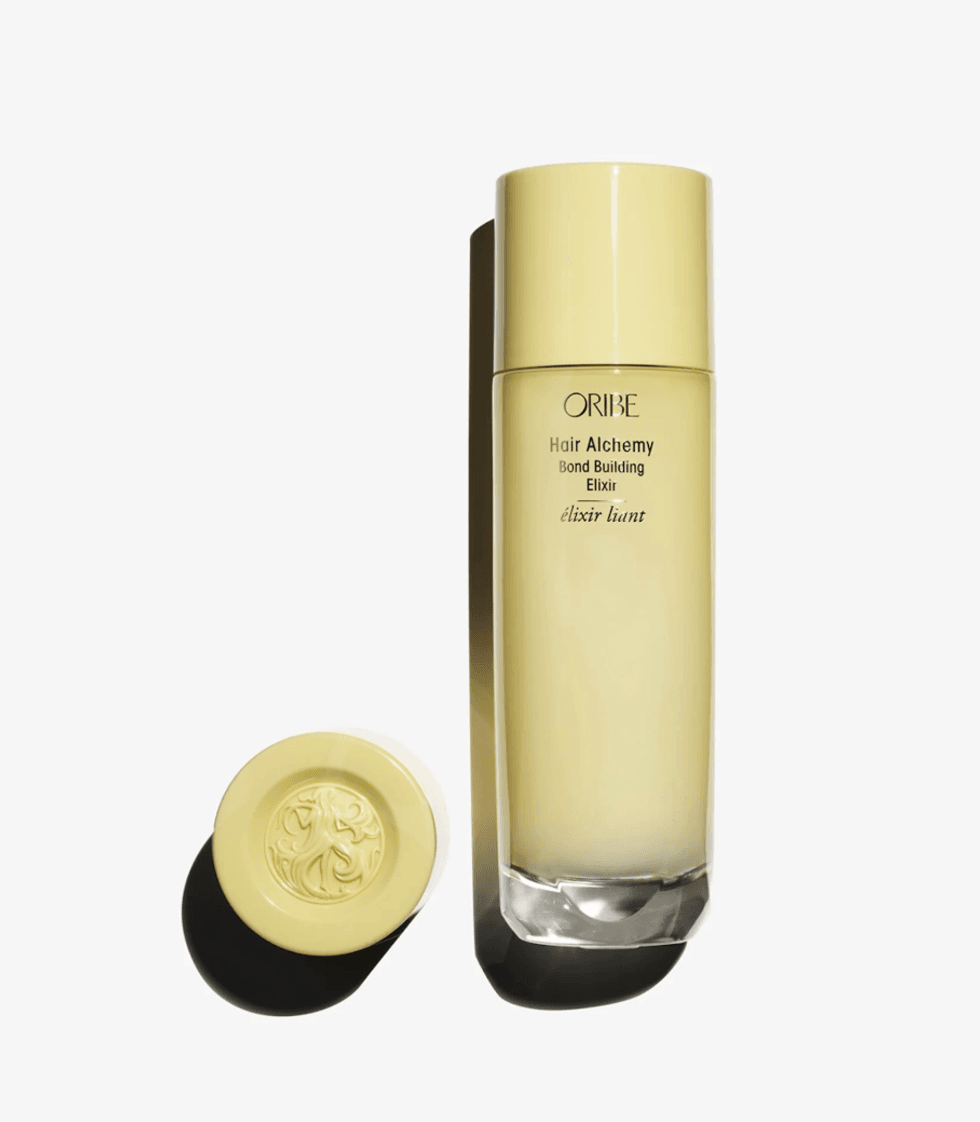 Yellow bottle of Oribe Hair Alchemy Bond Building Elixir shown with its cap.