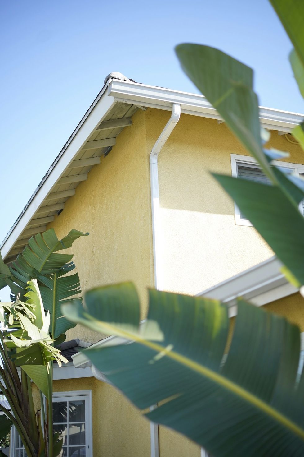yellow home cleaning the gutters