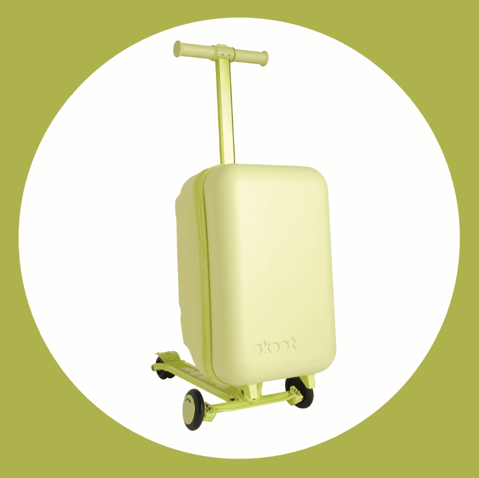 Yellow scooter suitcase with handle and wheels on a green background.