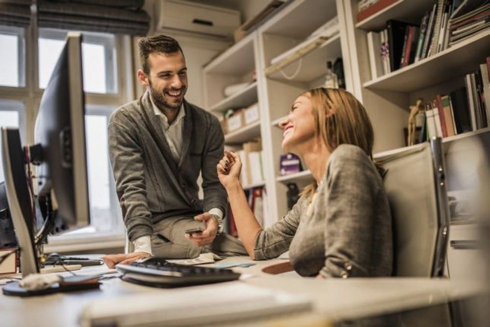 Young cheerfu coworkers flirting