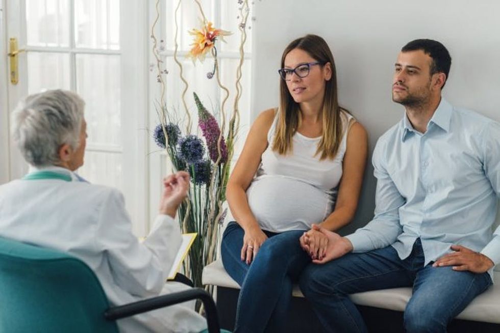 Young Couple And Female Doctor In A Consultation.