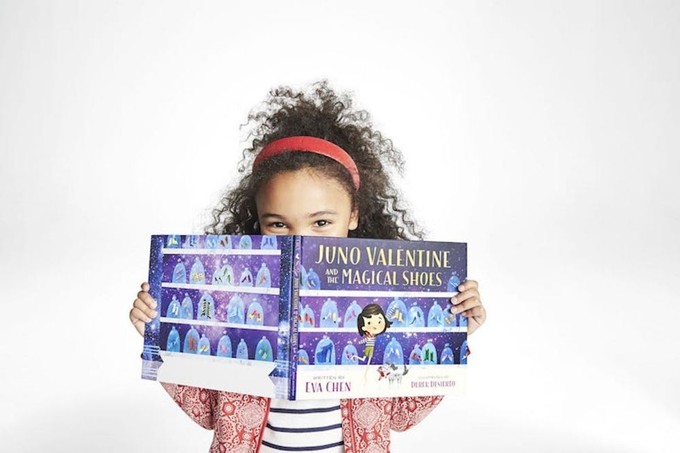 Young girl holding Juno Valentine and the Magical Shoes book