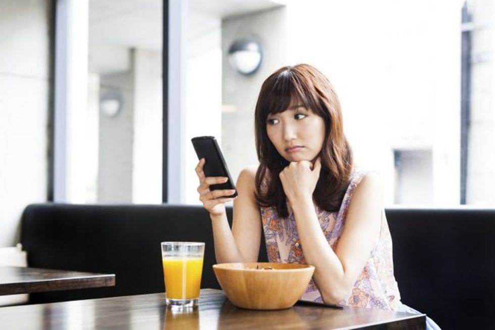 Young-girl-sadly-looking-at-her-phone-000073983091_Medium