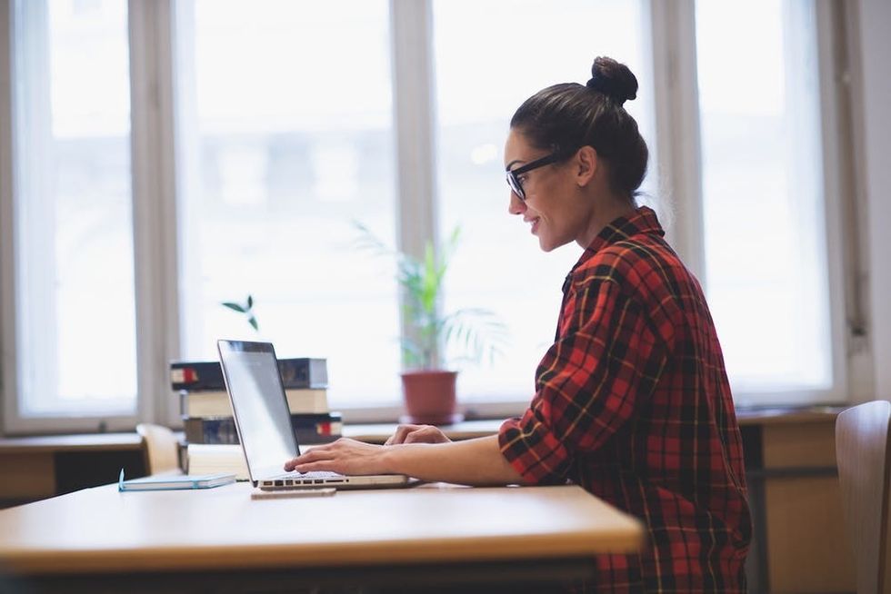 Young hipster girl working on laptop